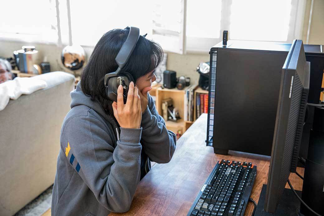 Person with headphones in front of a gaming PC